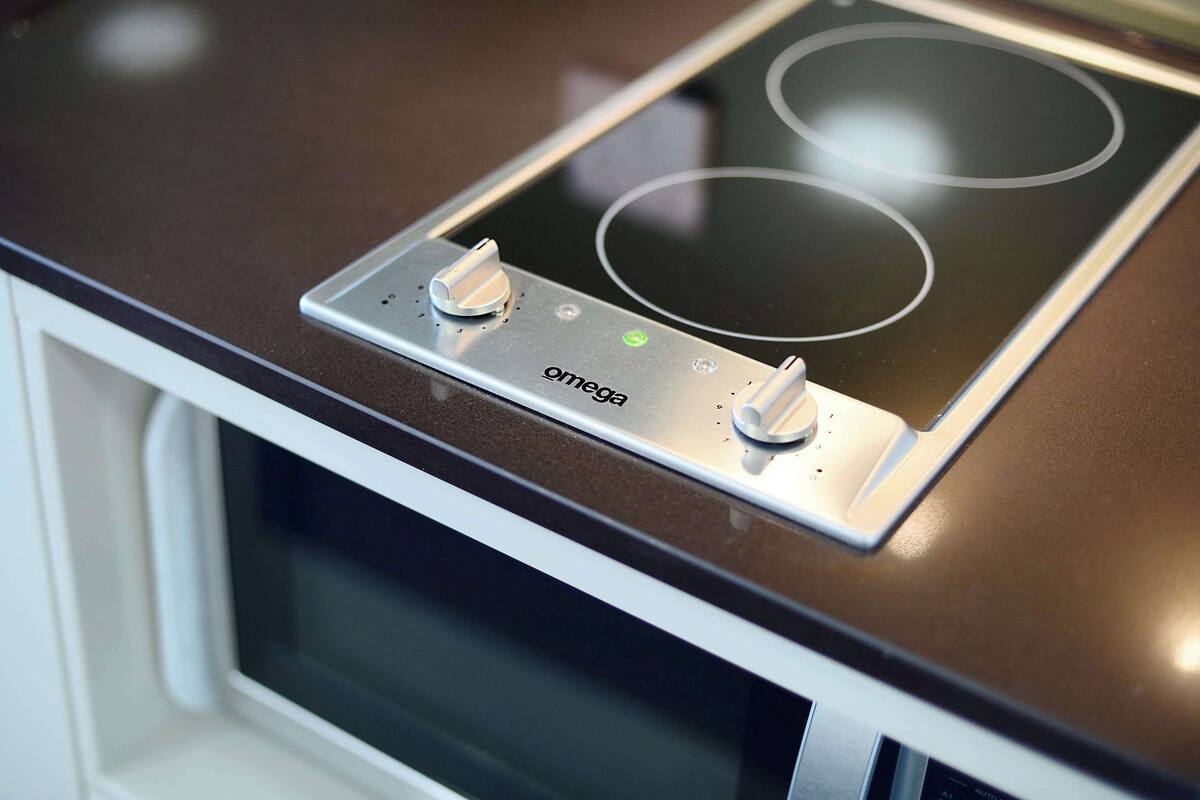 Una cocina con placa de inducción y microondas.