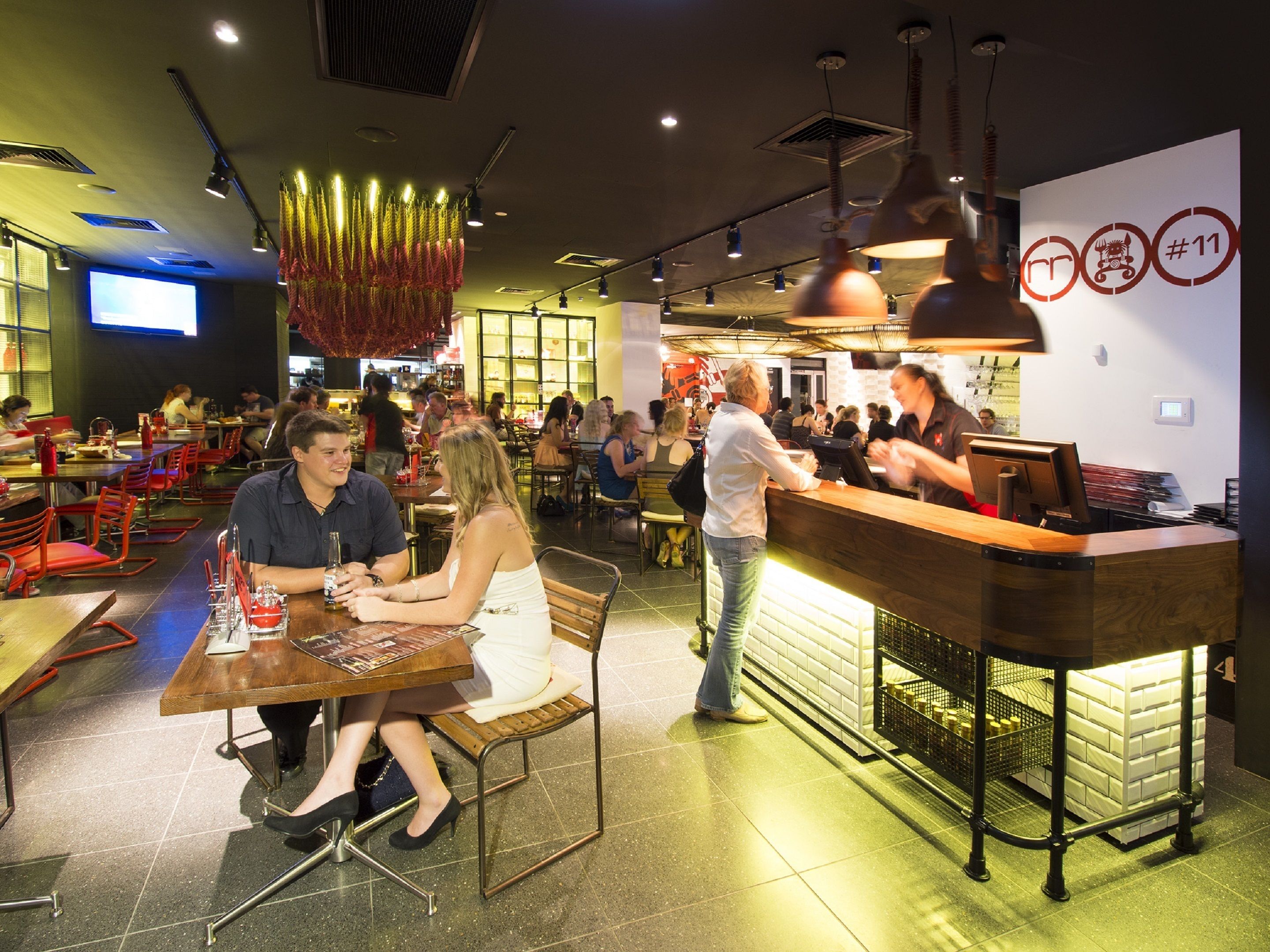 Un ristorante con area bar, diversi tavoli e sedie.