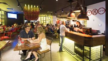 Un ristorante con area bar, diversi tavoli e sedie.