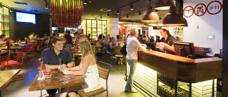 A restaurant with a bar area, multiple tables, and chairs.