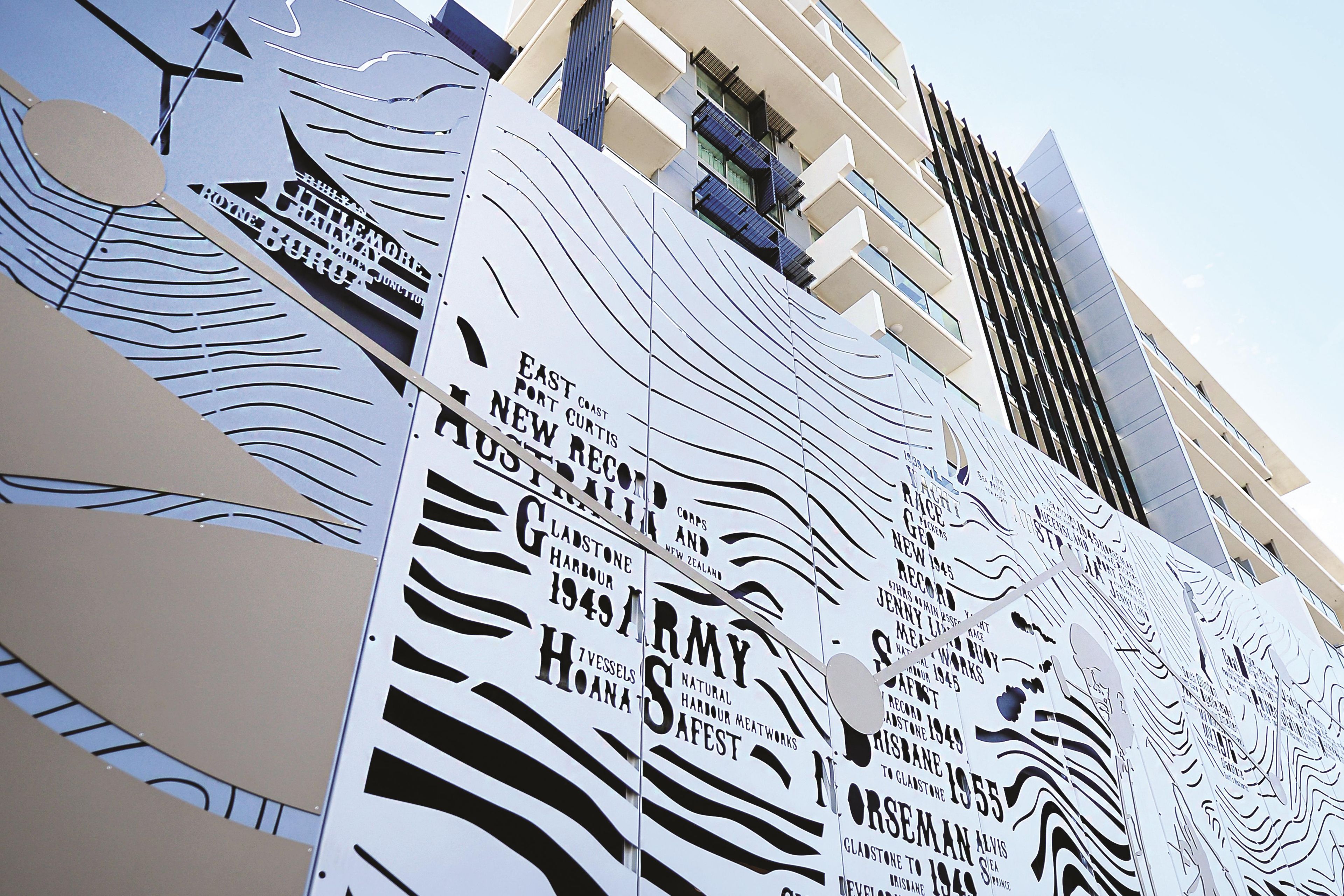 Fachada de edificio con paneles verticales que muestran texto y diseños.