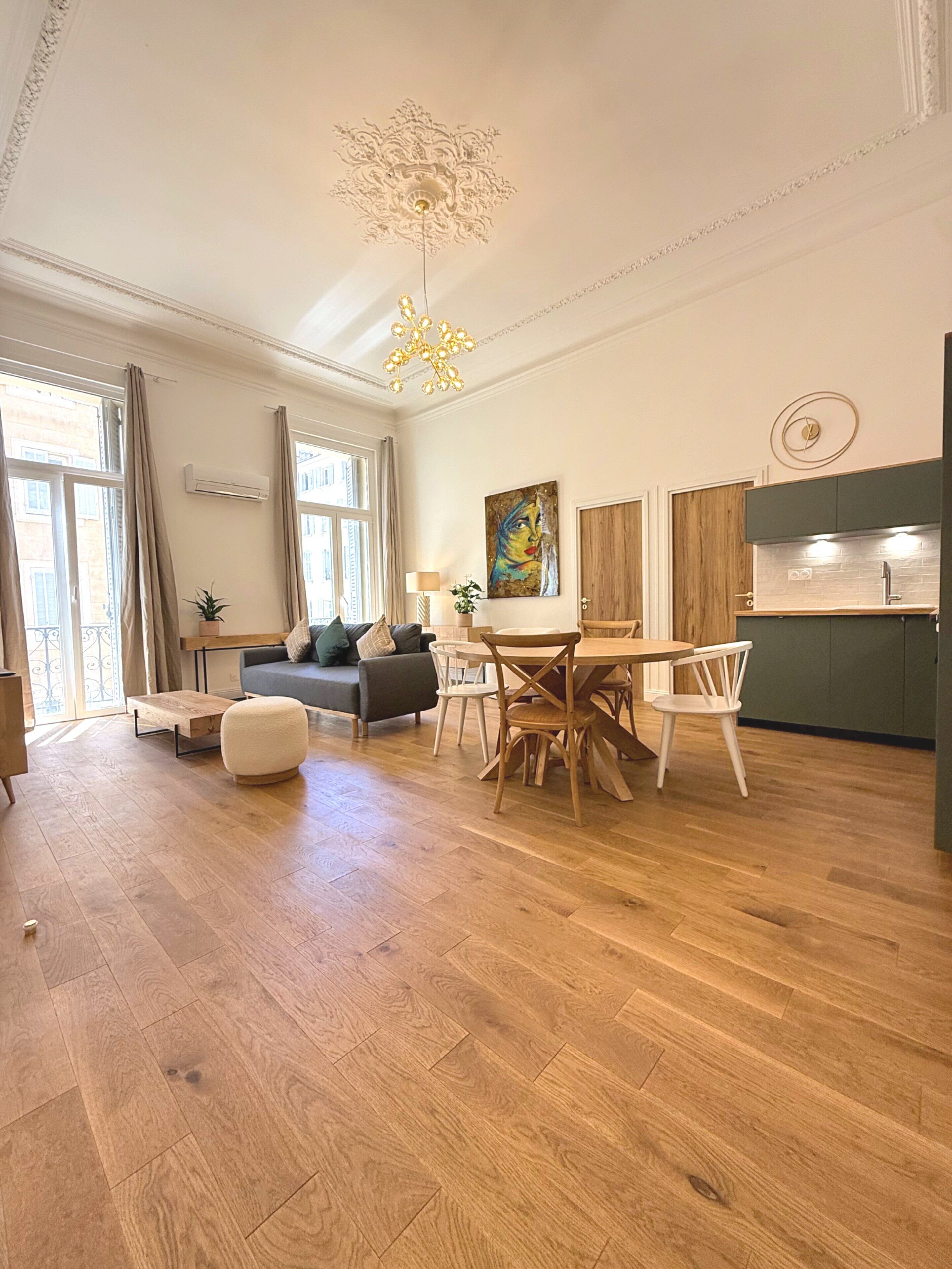 Amplia sala de estar con mesa de comedor, sillas, sofá y zona de cocina.