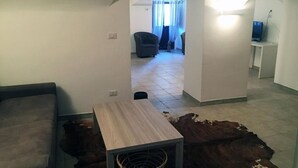 Ein kleiner Wohnbereich mit Sofa, Tisch und Teppich.