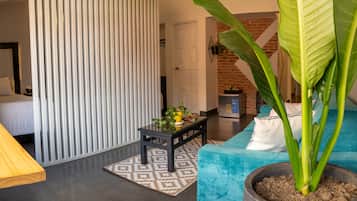 Una sala moderna con un sofá, una mesa de centro, una planta grande y un radiador.