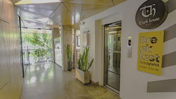 Un pasillo con un diseño geométrico en el techo, un letrero que dice 'Turk House' y un anuncio de 'desayuno express' que indica un servicio de 7:00 a las 10:00.