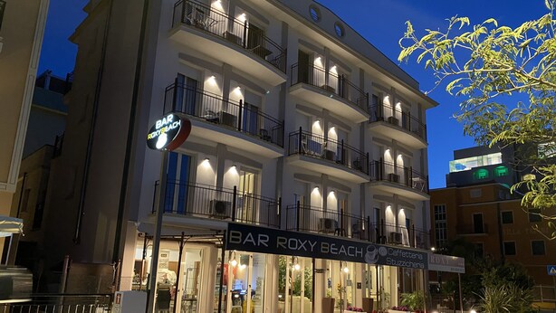 Ett hotell med flera våningar, balkonger, en bar och uteservering.