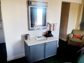 Une salle de bain équipée d’un lavabo, d’un miroir et d’un porte-serviettes.