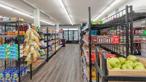 Een gang in een supermarkt met schappen vol diverse producten, waaronder snacks, ontbijtgranen en dranken.