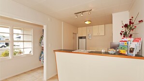A kitchen with a wooden countertop, a refrigerator, and a window with a view of the outside. - Colonial Inn Motel (Christchurch)