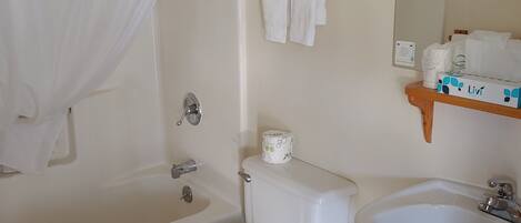 A bathroom with a bathtub, toilet, and sink.
