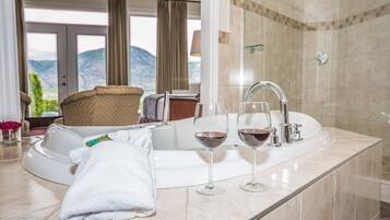 A modern bathroom with a bathtub, two wine glasses, and a towel.