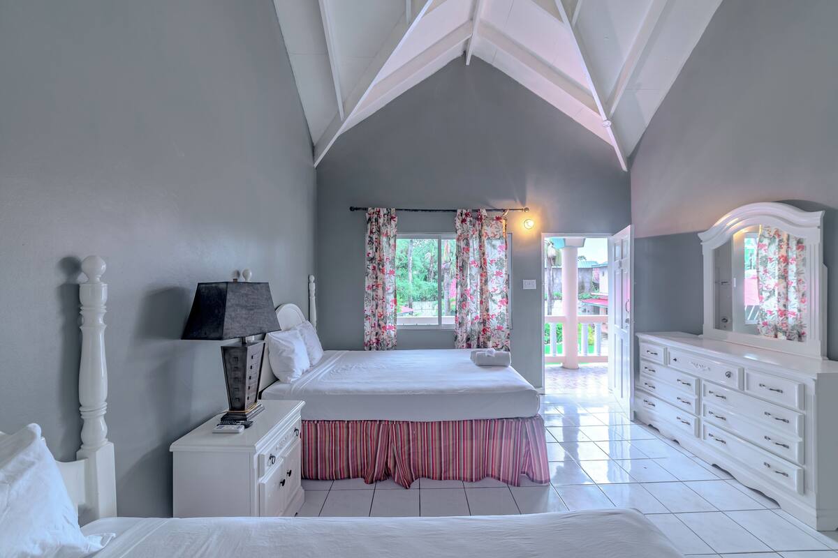 Une chambre à coucher avec un grand lit, une commode, une table de chevet et un miroir.