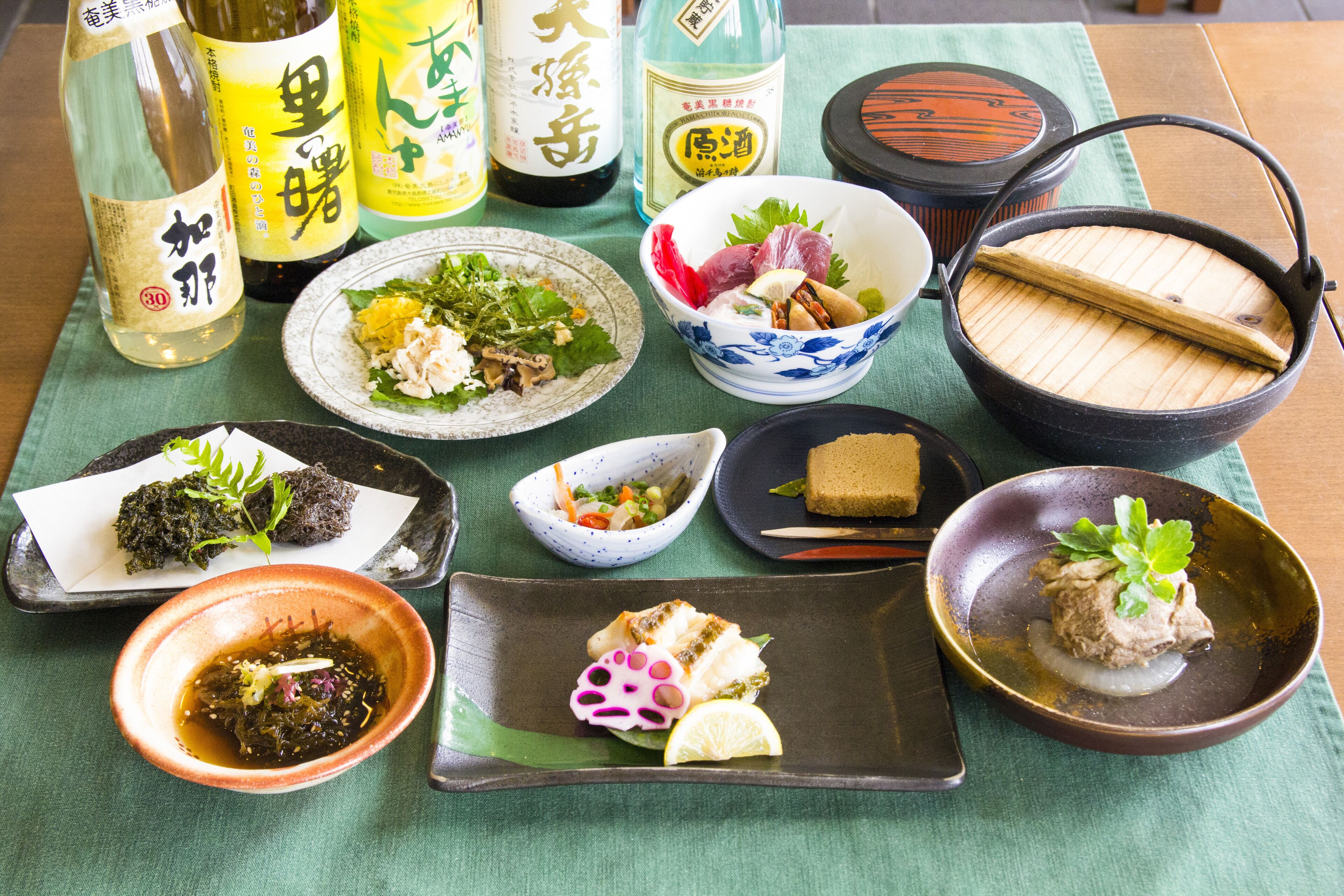 Variedad de platos y bebidas japonesas sobre una mesa.