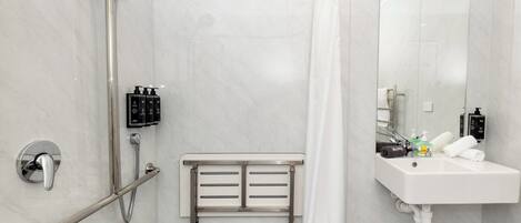 Een moderne badkamer met douche, toilet en wastafel.