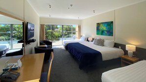 A hotel room with a bed, a desk, a chair, a TV, and a painting. - Saxton Lodge (Nelson)