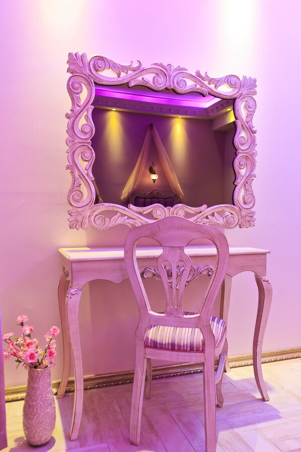 A vanity area with a mirror, vanity table, and chair. - Elegance Residence (Istanbul)