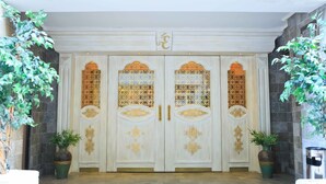 A grand entrance with a double door, decorative panels, and two potted plants. - Elegance Residence (Istanbul)