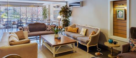 Amplia sala de estar con un conjunto de sofás, una mesa de centro y una mesa de comedor con sillas.