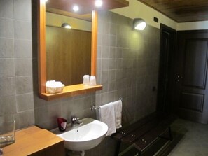 A bathroom with a large mirror, a sink, and a towel rack. - Casa Alpina Don Guanella (Macugnaga)