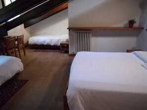 A bedroom with two beds, a desk, and a chair. - Casa Alpina Don Guanella (Macugnaga)