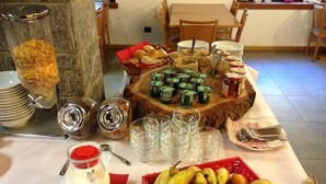 A breakfast buffet setup with various food items and condiments. - Casa Alpina Don Guanella (Macugnaga)