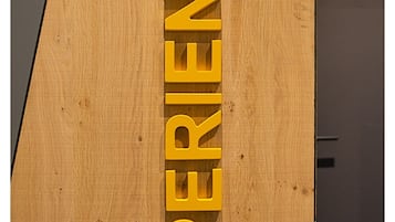 Un panel de madera con la palabra 'EXPERIENCE' en letras mayúsculas y negritas.