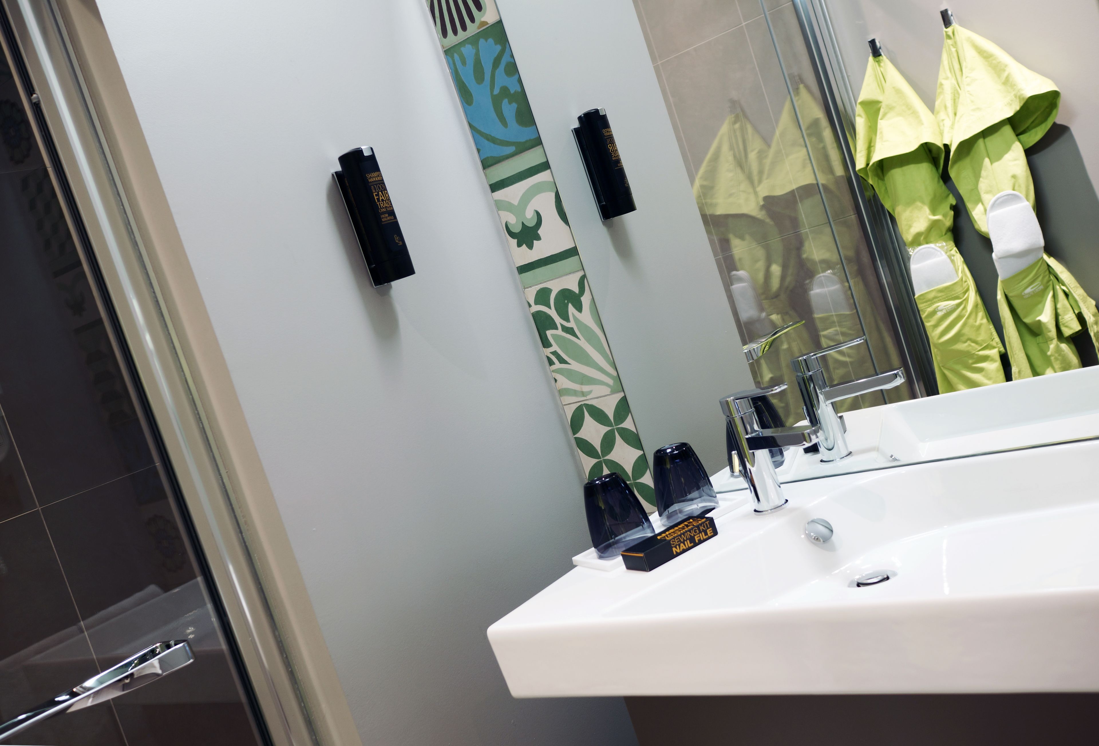 A bathroom with a white sink, a mirror, and a glass shower enclosure.