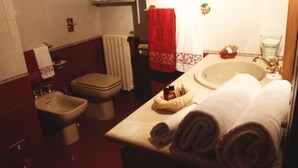 Une salle de bain équipée d’un lavabo, d’un bidet, de toilettes et d’un porte-serviettes avec des serviettes.