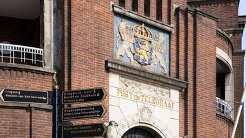 Un bâtiment orné d’un blason bien visible et sur lequel on peut lire les mots « POSTE ET TÉLÉGRAMME » sur la façade.
