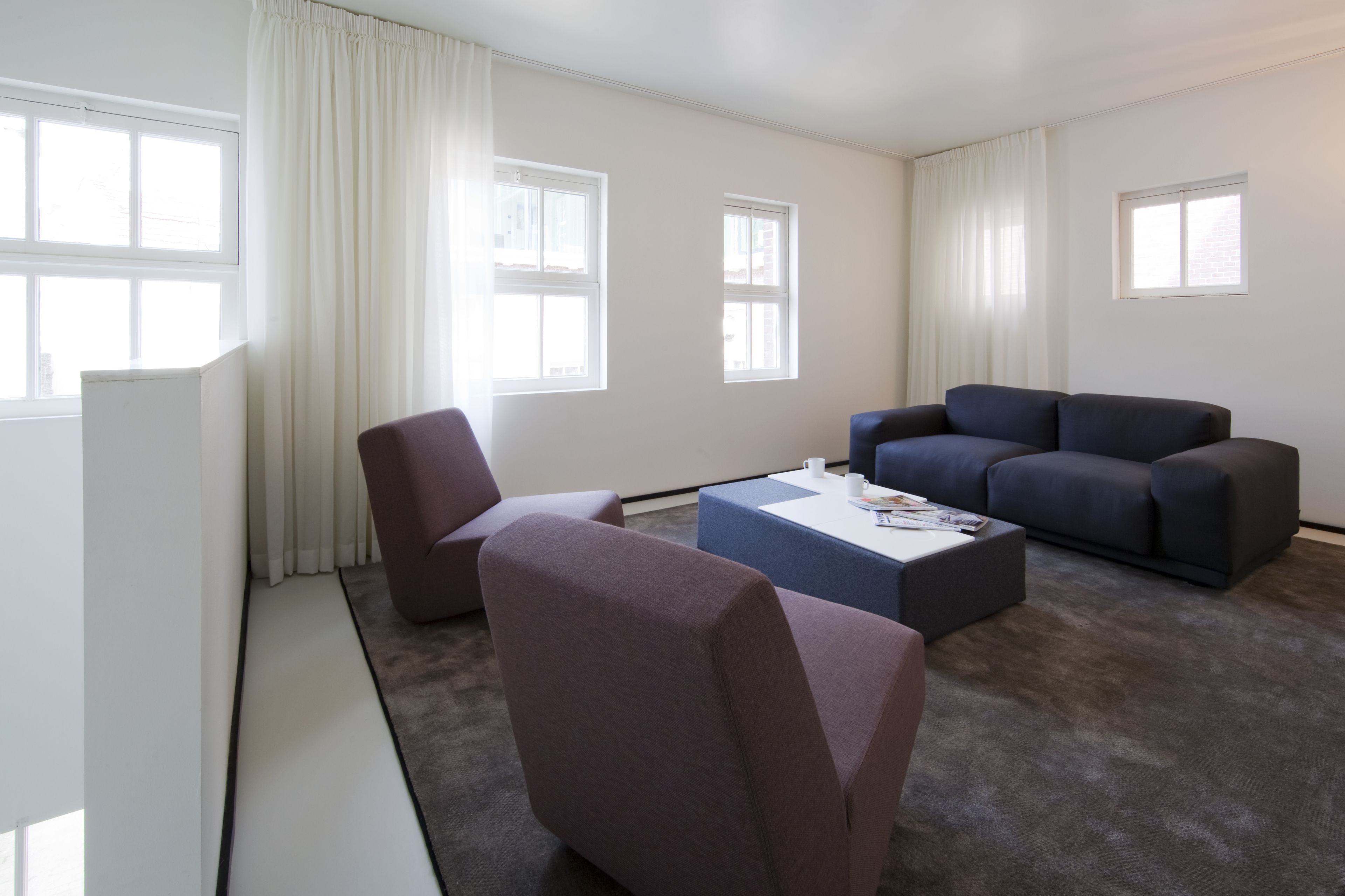Una sala de estar moderna con sofá, sillón y mesa de centro.