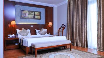 Relax in a spacious room with a large bed, nightstand, and comfortable seating area.