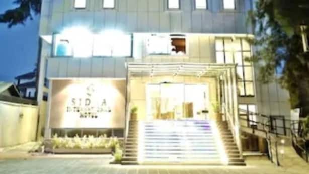 Un hotel de varios pisos con un cartel llamativo que dice 'SIDRA INT'L HOTEL'.