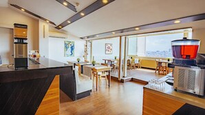 Una cocina moderna con una isla grande, una cafetera y un dispensador de agua rojo.