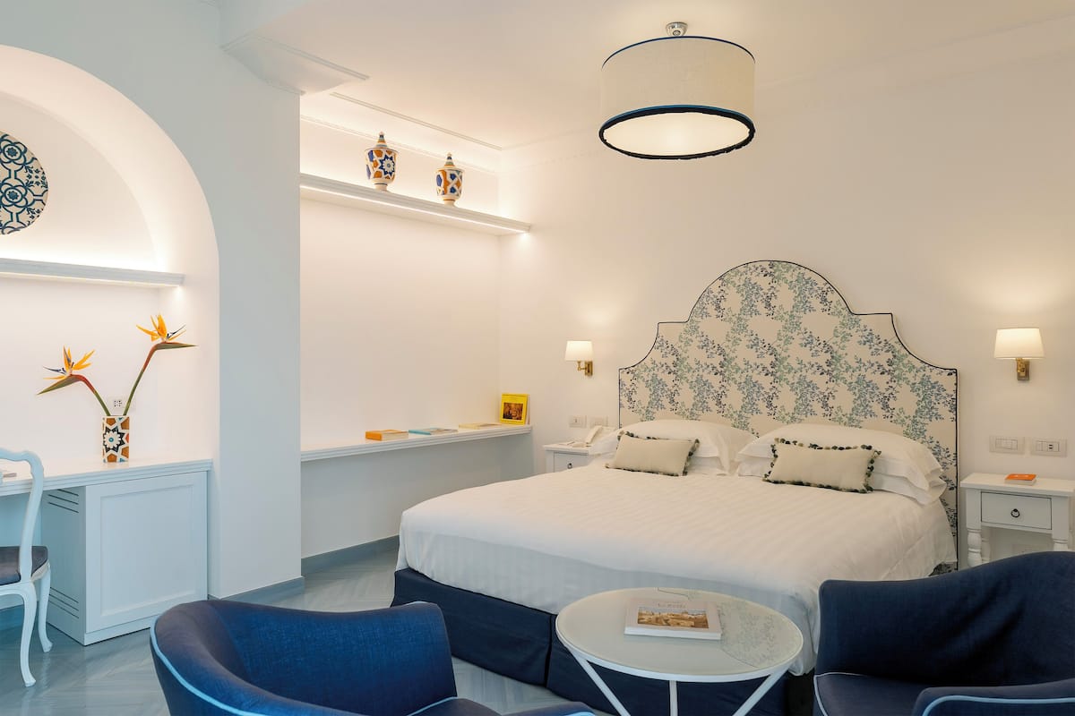 Una habitación de hotel moderna con una cama grande, un escritorio y dos sillas.