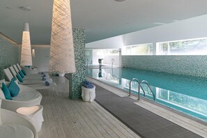 A modern indoor pool area with lounge chairs and a clear view of the pool. - The Grand Hotel Punta Del Este (Punta del Este)