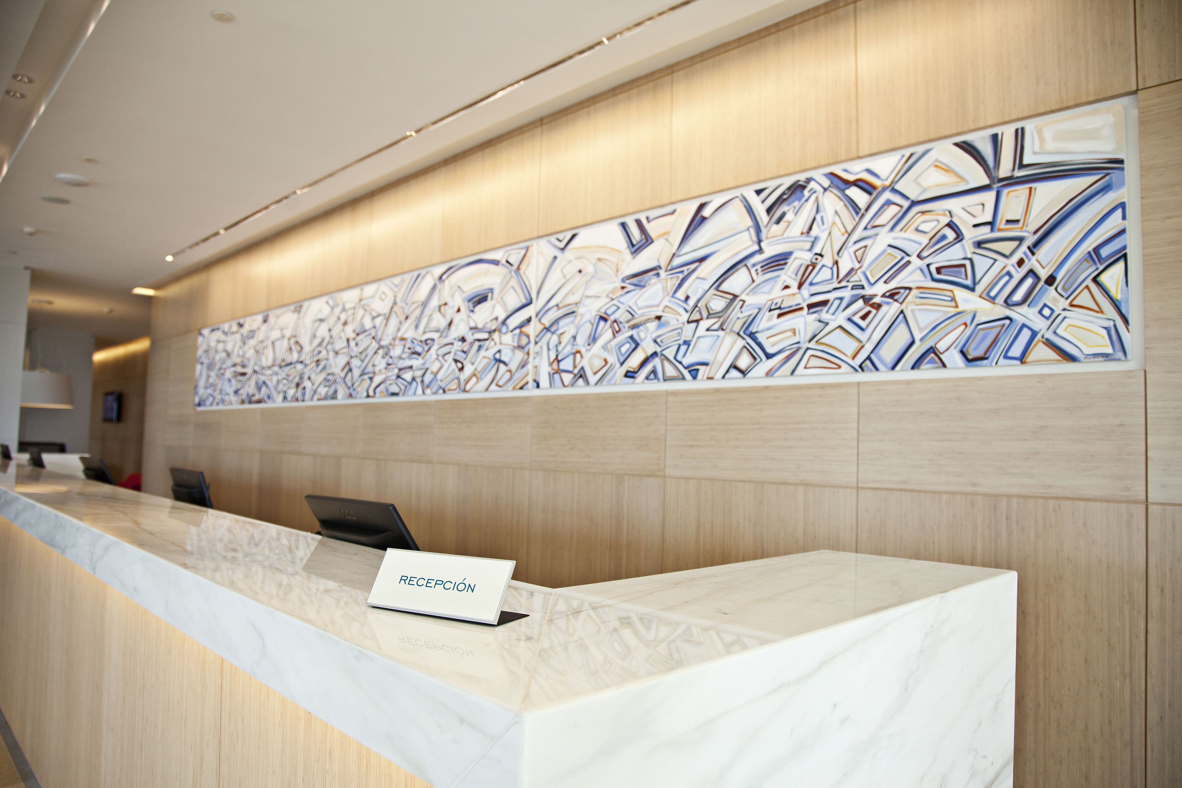 A reception desk with a marble top and a sign that reads "RECEPCIÓN".