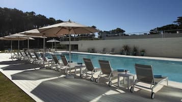 Alberca techada, alberca al aire libre y camastros