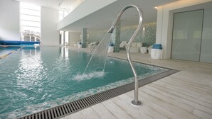 An indoor swimming pool with a modern design, clear water, and a metal fountain. - The Grand Hotel Punta Del Este (Punta del Este)
