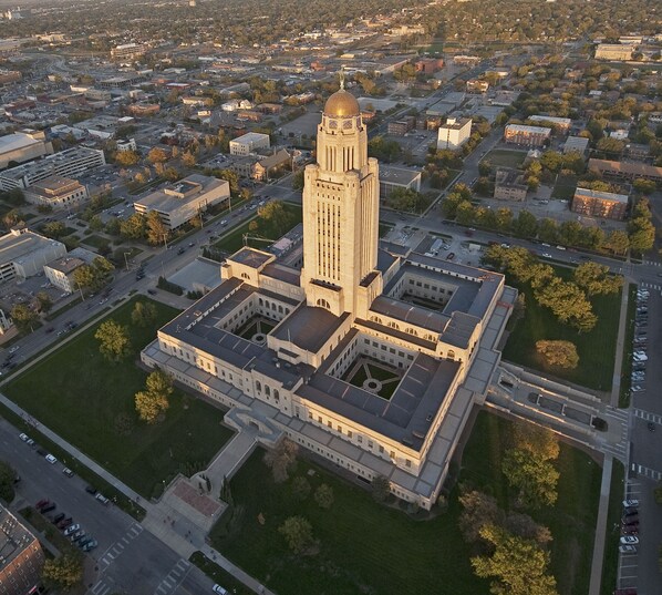 An aerial view of a large, historic building with a central tower and a symmetrical courtyard.