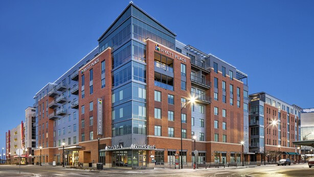 Een meerlaags hotel met een opvallend 'Hyatt Place' bord, een vestiging van 'Pinnacle Bank' en een modern architectonisch ontwerp.