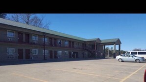 A motel with a parking lot and a covered area. - City Heart Inn & Suites (Piedmont)