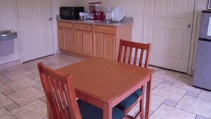 A kitchen with wooden cabinets, a microwave, and a refrigerator. - City Heart Inn & Suites (Piedmont)