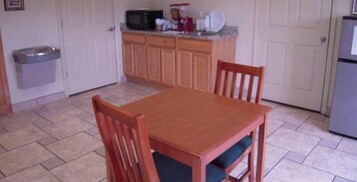 Una cocina con armarios de madera, un microondas y un refrigerador.