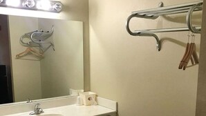 A bathroom with a sink, mirror, and towel rack. - City Heart Inn & Suites (Piedmont)