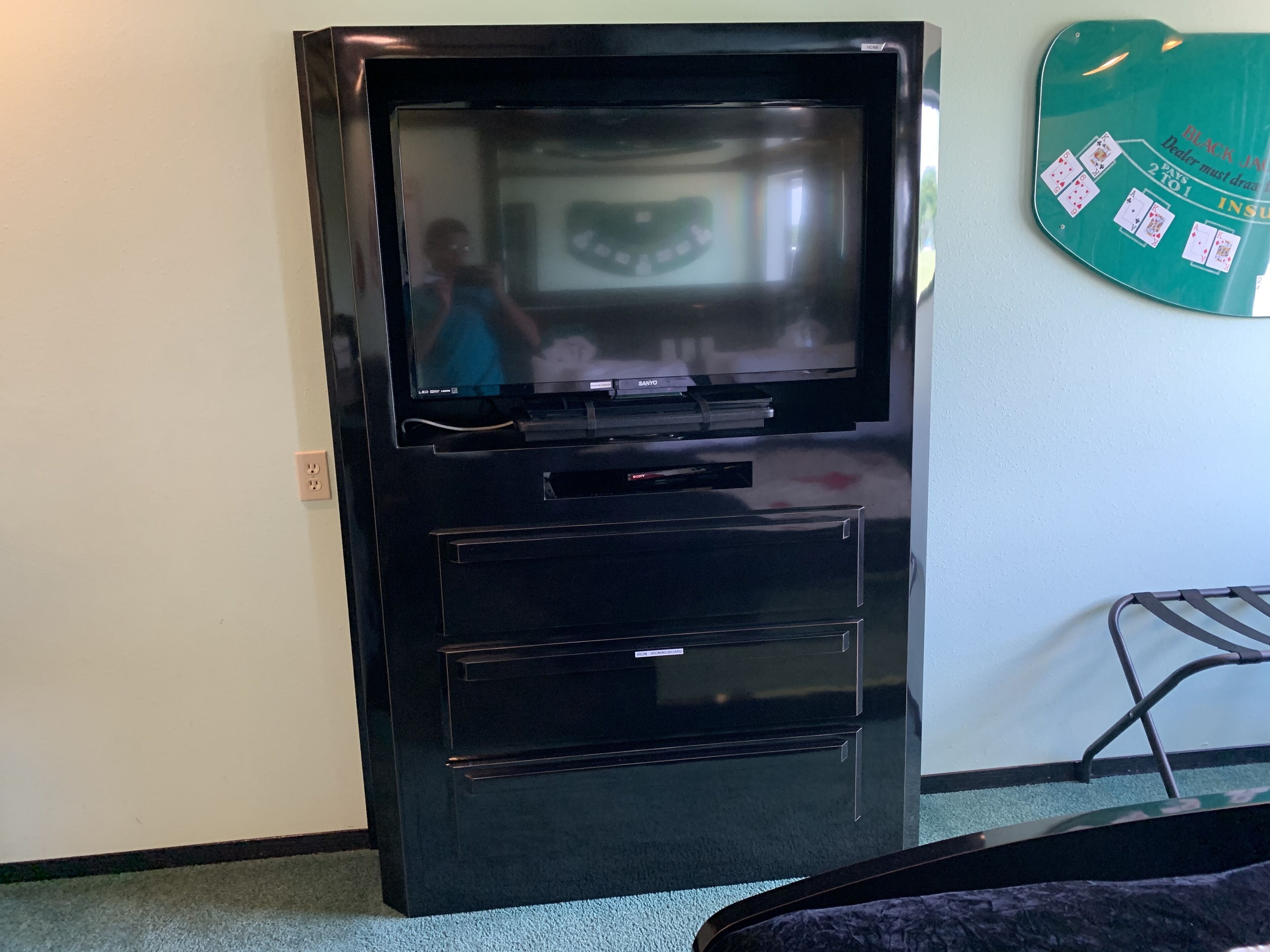 A black television set with a screen, a DVD player below it, and a small drawer unit.