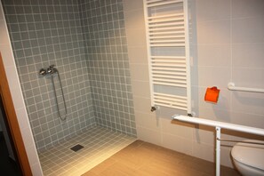 A bathroom with a shower, tiled walls, a toilet, and a towel rack. - Cibos 3000 (Sant Julia de Loria)