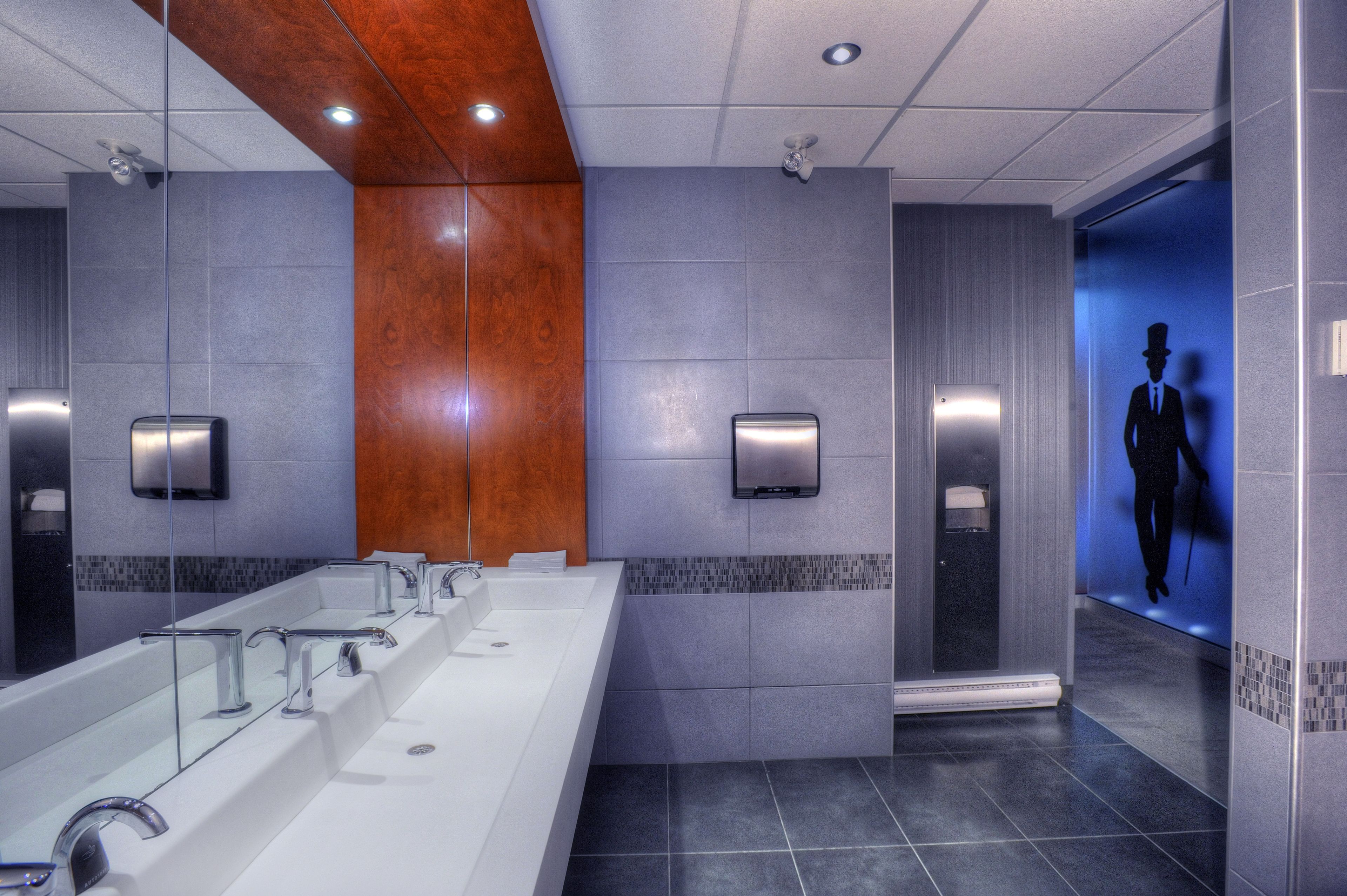 Ein modernes Badezimmer mit einem großen Waschbecken, Spiegeln und einer Wand aus Holz.