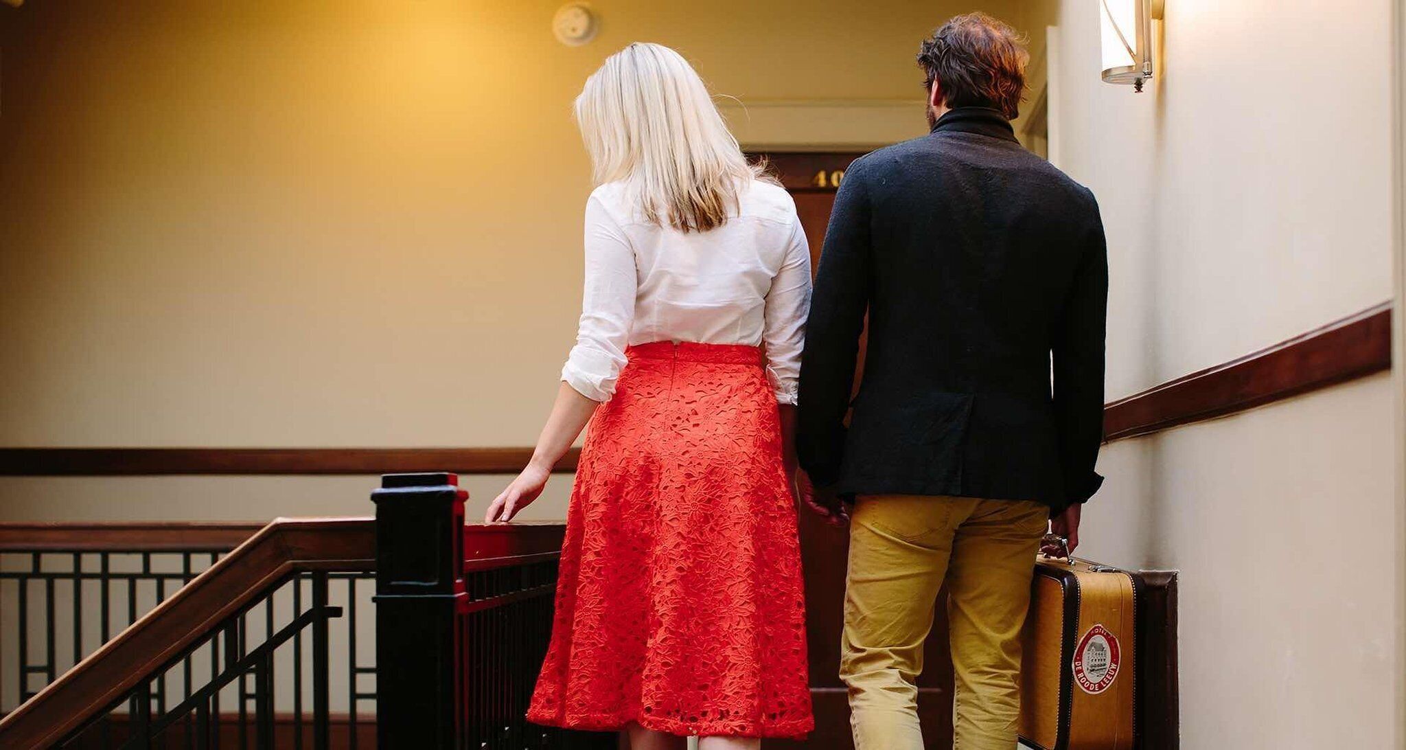 A man and a woman walking down a staircase in a building.