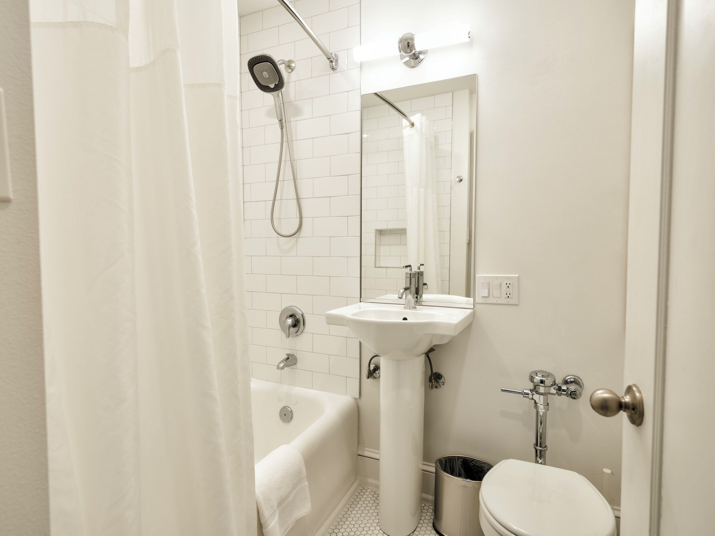 Un baño con bañera, lavamanos, inodoro y ducha.