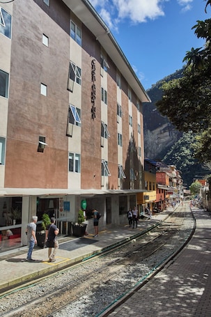 A hotel with a modern architectural design, located near a railway station.